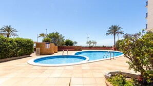 A rooftop swimming pool area with two pools, surrounded by palm trees and a clear blue sky. - Apartment Garbi by Interhome (Cunit)