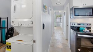 Un cuarto de lavandería con lavadora y secadora de carga frontal, microondas y horno.