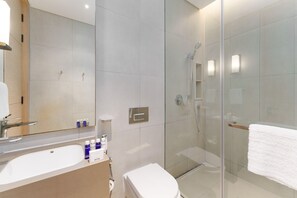 A modern bathroom with a glass-enclosed shower, a white sink, and a toilet. - Luxury Living w/ Superb Sea Views in Address JBR (Dubai)