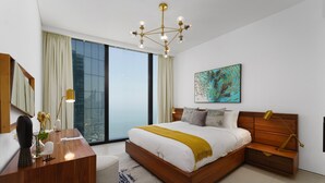 Un dormitorio moderno con una cama grande, un escritorio y un ventanal amplio.