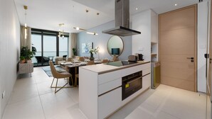Una cocina moderna con una isla central, horno empotrado y un amplio ventanal con vistas al exterior.