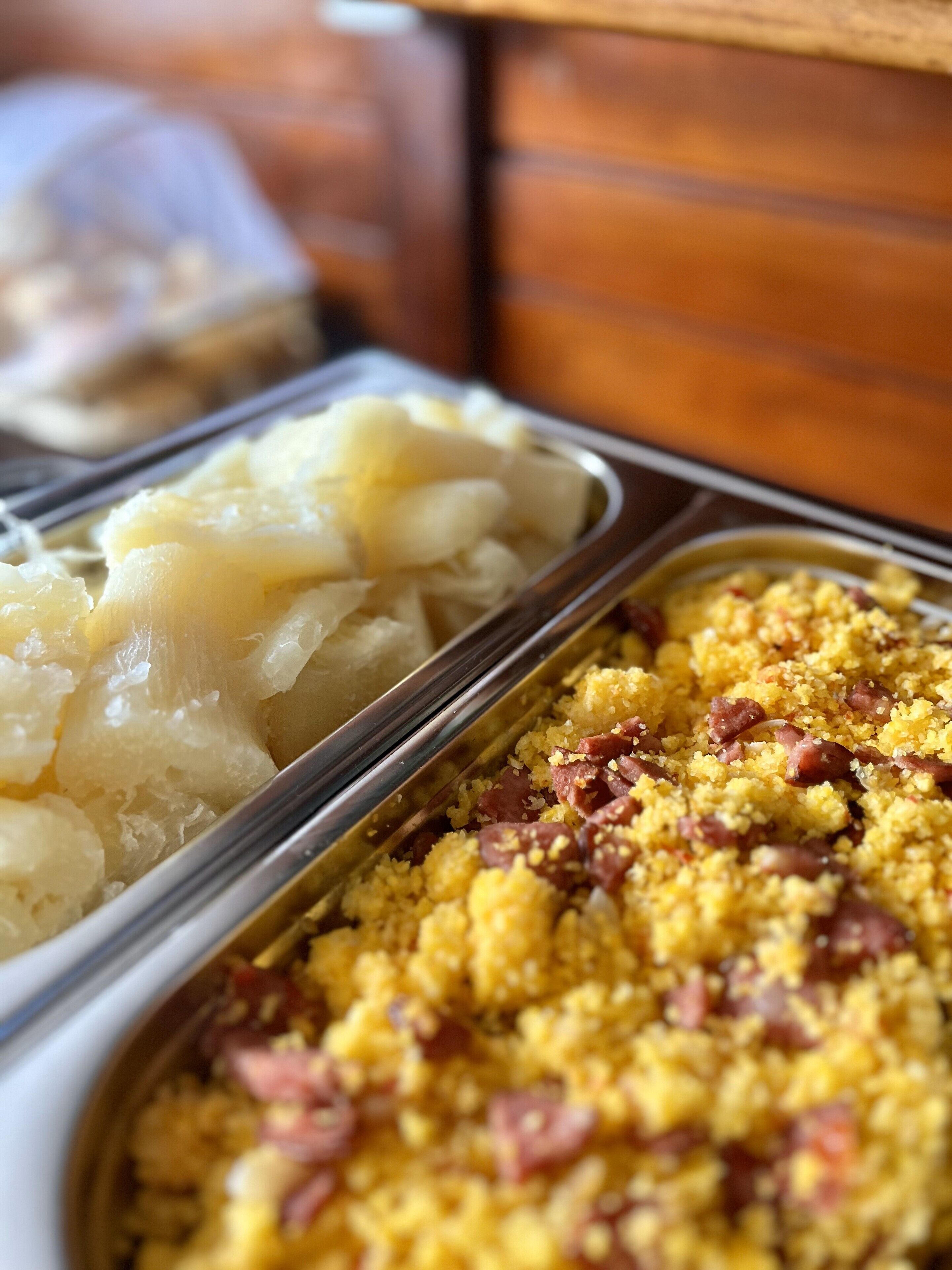 A buffet with various dishes including potatoes, a yellow grain dish, and a red meat dish.