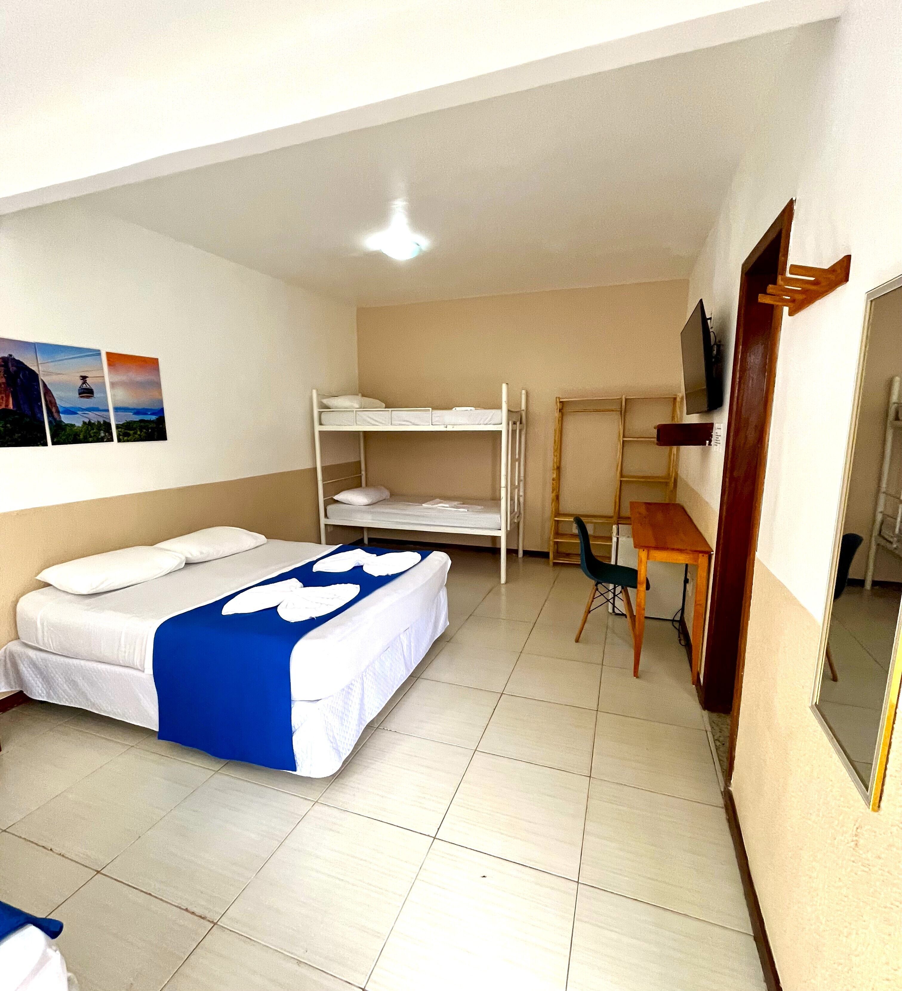 Ein Zimmer mit Etagenbetten, einem Schreibtisch und einem Stuhl.