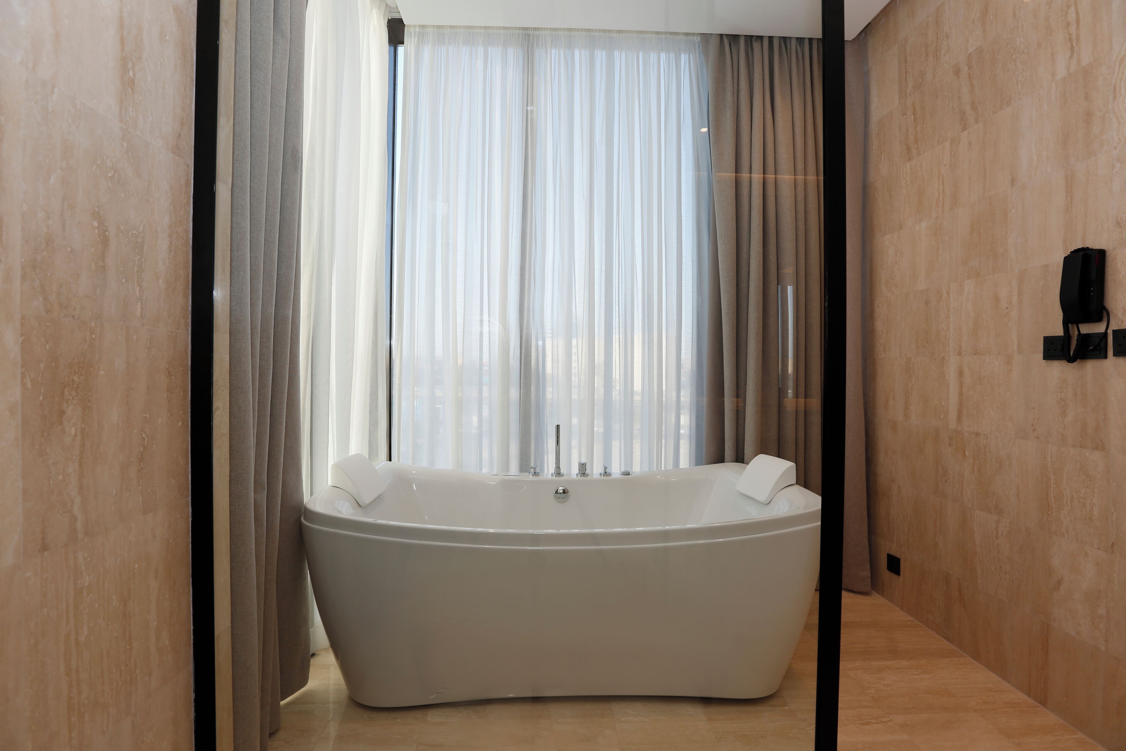 A modern bathroom with a freestanding bathtub, a glass shower enclosure, and a marble floor.