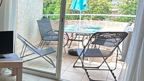 Ein Zimmer mit einer Schiebetür zu einem Außenbereich mit Pool, Stühlen und einem Tisch.