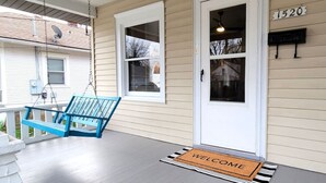 A porch with a blue swing, a white door, and a 'WELCOME' mat. - Fully Fenced Yard, Dogs Welcome, Near MSU and Cox South (Springfield)