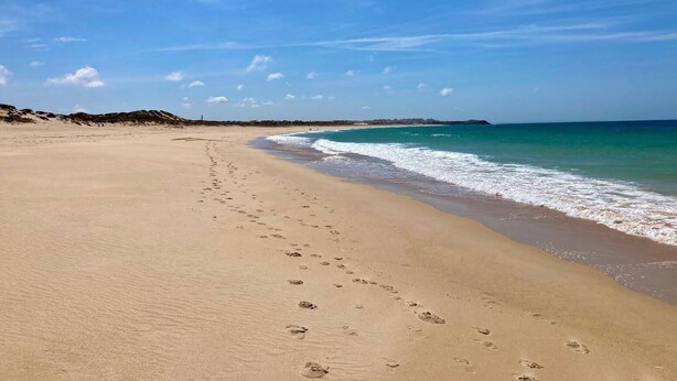A wide sandy beach with footprints leading to the water, a clear sky, and a distant landmass. - 5 Bed Country Villa with Large Heated Pool near Óbidos (A dos Ruivos)