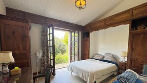 Une chambre à coucher comprenant un lit, un bureau, une chaise, une lampe et une vue sur l’extérieur.