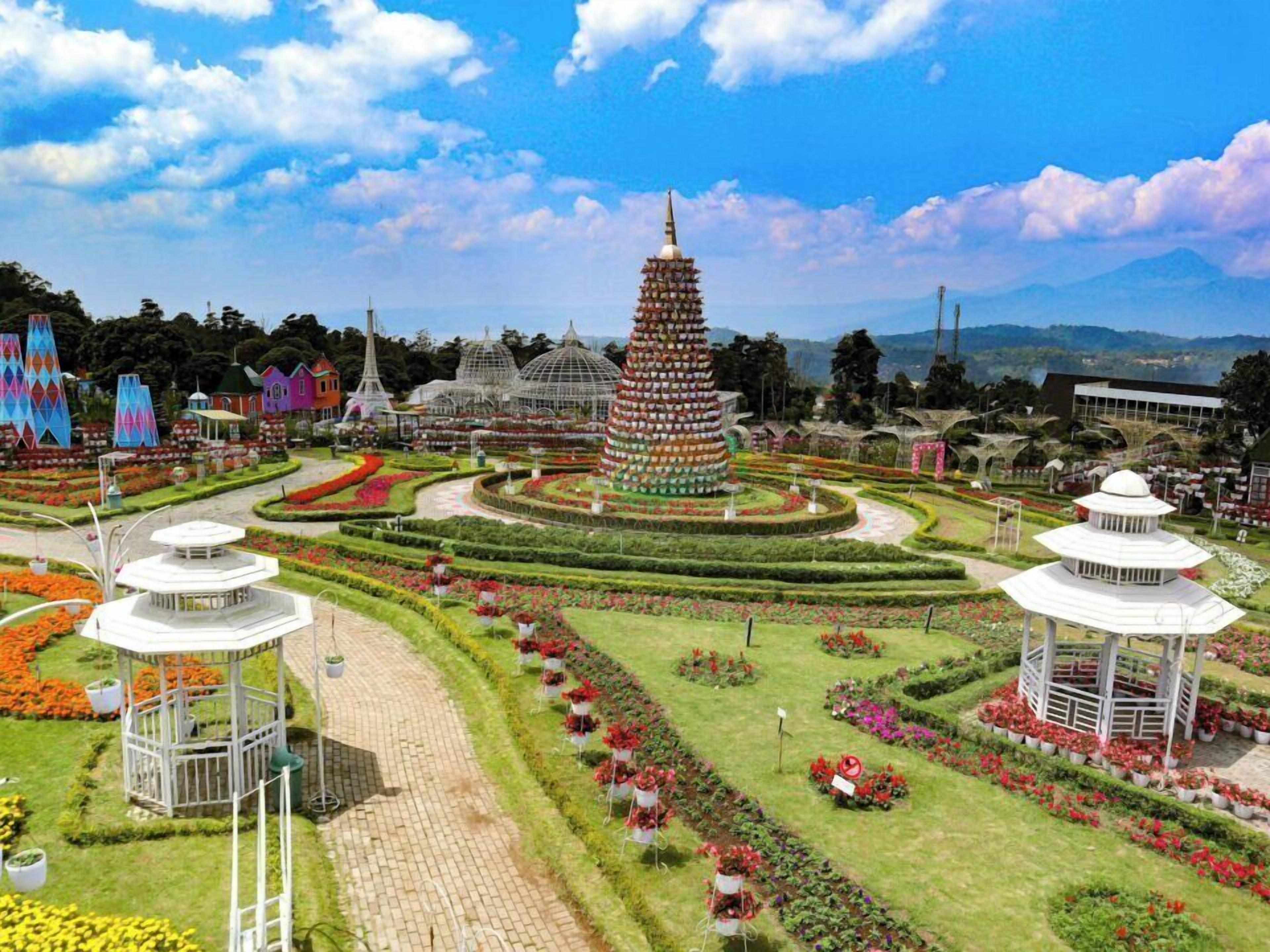 A garden with a central tower, pathways, and various structures.