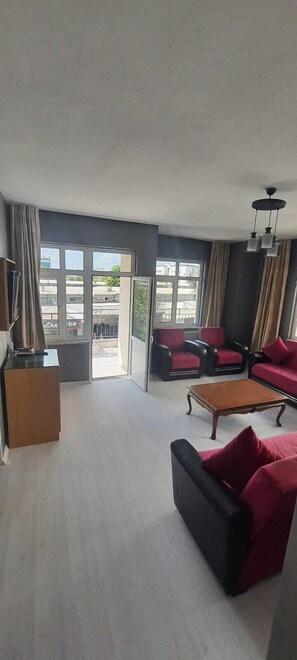 Habitación familiar con 1 cama matrimonial o 2 individuales, balcón, vista a la ciudad | Área de sala de estar