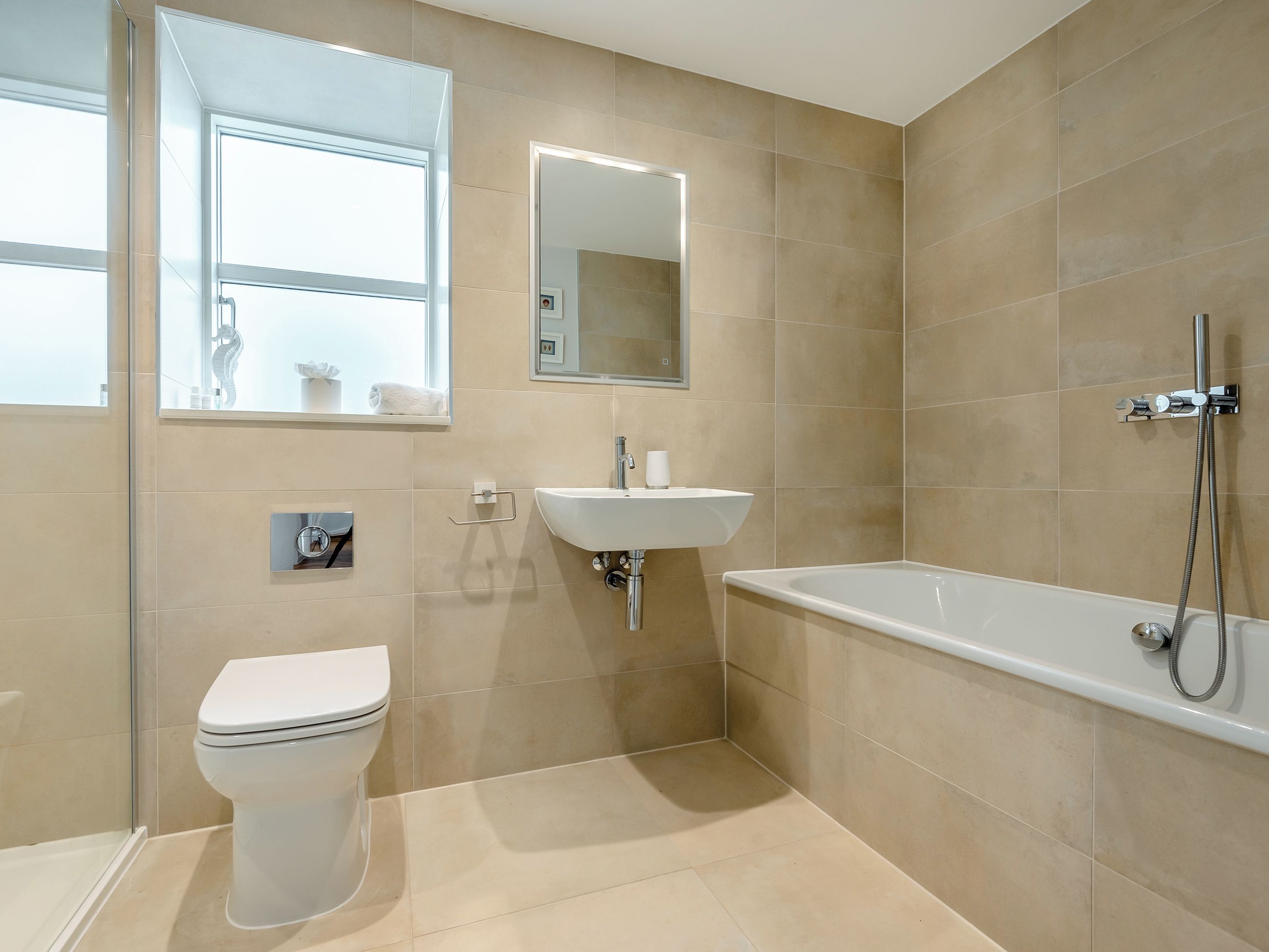 A modern bathroom with a toilet, sink, and bathtub.