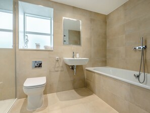 Un baño moderno con inodoro, lavamanos y bañera.