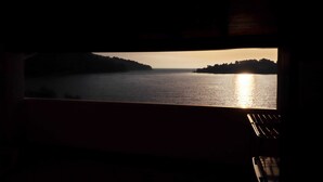 A view from a window overlooking a body of water with a sunset. - Seafront Apartments Anthony (Lastovo)