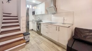 Una cocina compacta con lavadora integrada, microondas y lavaplatos.
