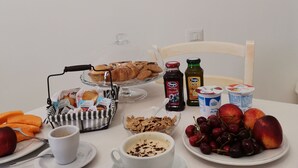 A breakfast table with pastries, fruits, and beverages. - Paluna (Otranto)