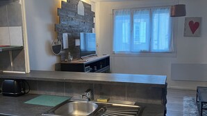 A modern kitchen with a large island, built-in appliances, and a view of the city through a window.