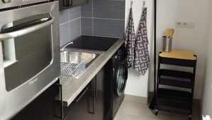 Una cocina moderna con horno de acero inoxidable, lavavajillas integrado y lavadora.