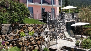 A two-story building with a balcony, stone walls, and outdoor seating. - Villa Buena Vista mit Beheiztem Pool und Sauna (Tijarafe)