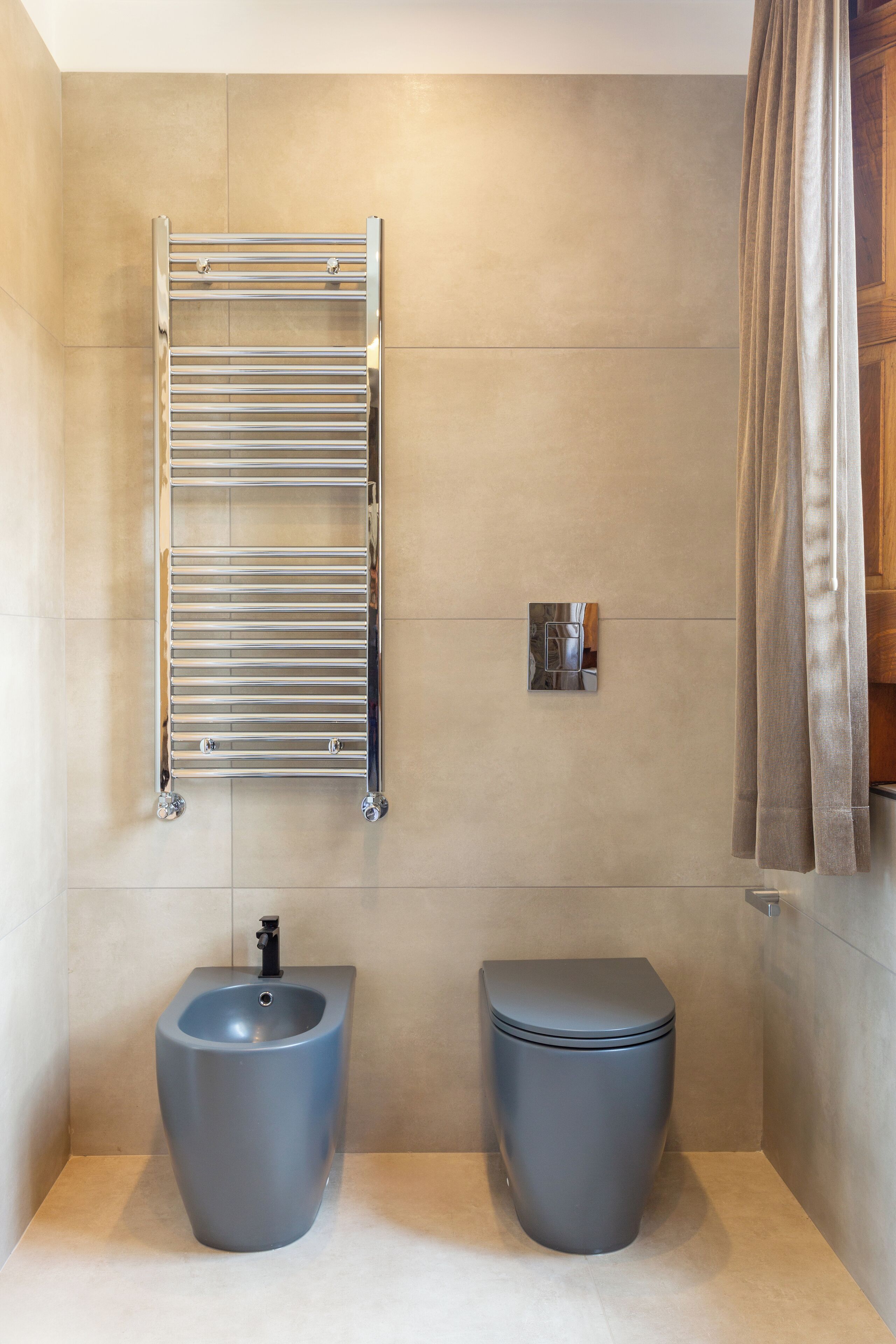 A modern bathroom with a bidet, toilet, and a towel rack.