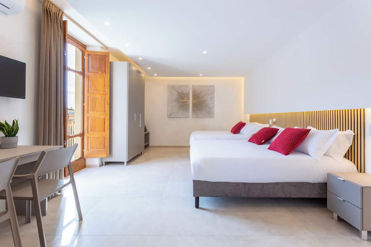 Une chambre à coucher moderne avec un lit, des tables de chevet, un bureau et une chaise.