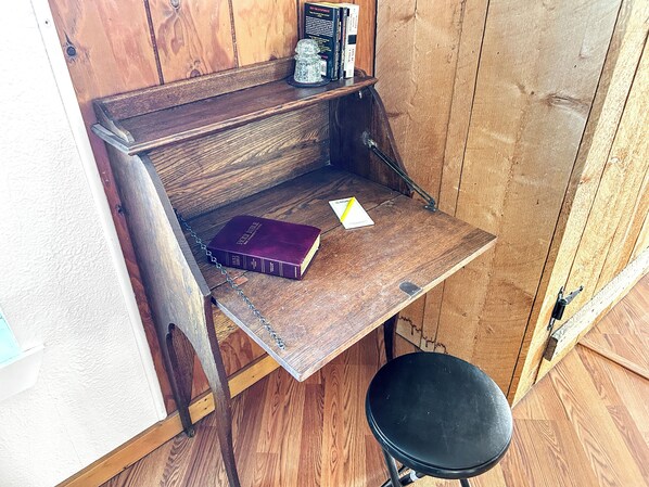 A corner desk with a book, a notepad, and a small decorative item.