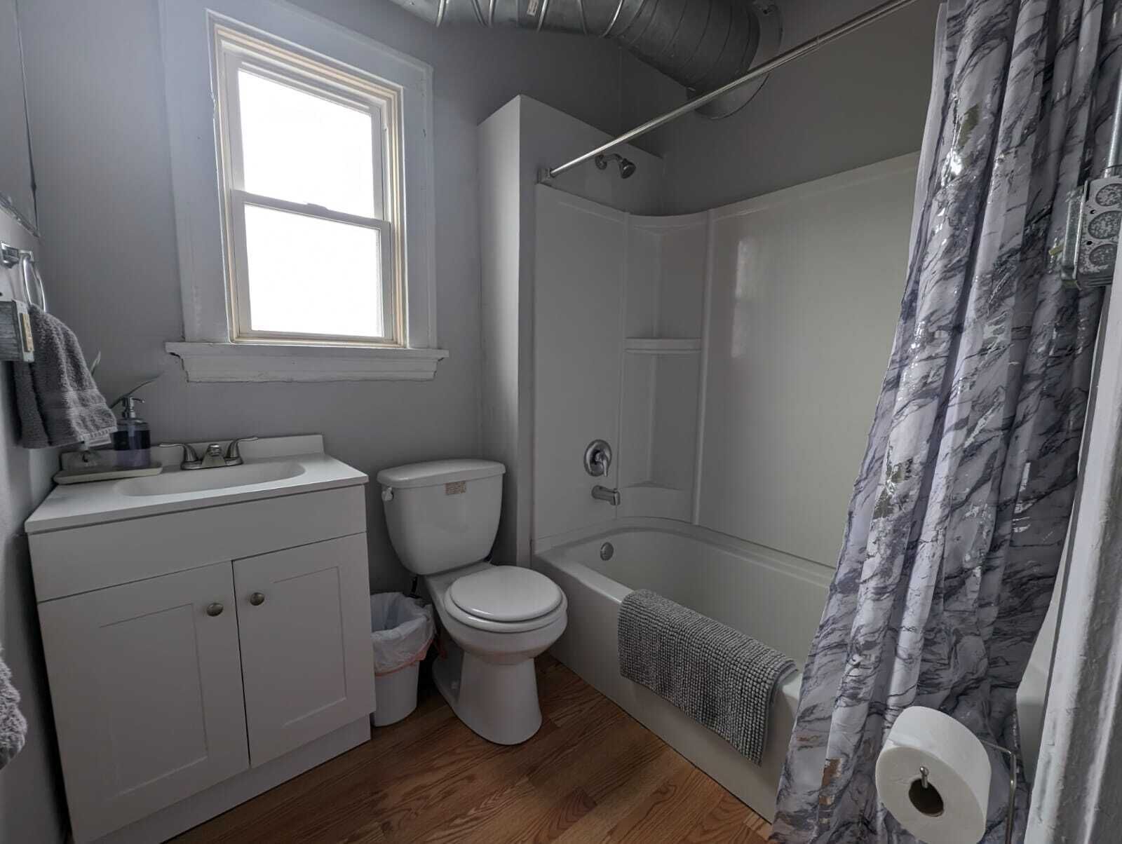Une salle de bain avec des toilettes, un lavabo et une baignoire.