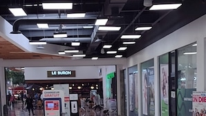 A spacious indoor area with a modern design, featuring a self-service kiosk, a sign for 'LE BURON', and a clean, reflective floor. - Belle Chambre Chaleureuse au Calme (Chennevières-sur-Marne)