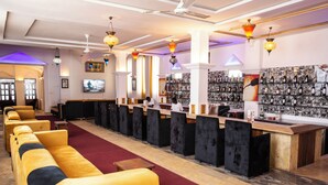 A hotel lobby with a reception desk, seating area, and a wall of framed pictures. - Coconut Residence & Spa (Serrekunda)
