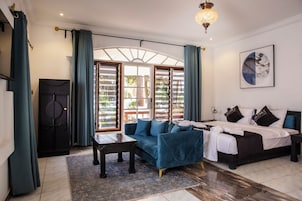 A modern bedroom with a bed, a sofa, a desk, and a wardrobe.