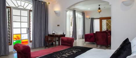 A hotel room with a bed, a desk, and two chairs.