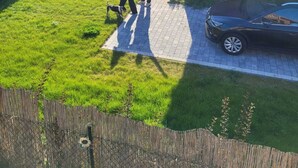 A backyard with a brick house, a swing set, and a paved area. - MoreView Kopice directly on the Szczecin Lagoon (Stepnica)