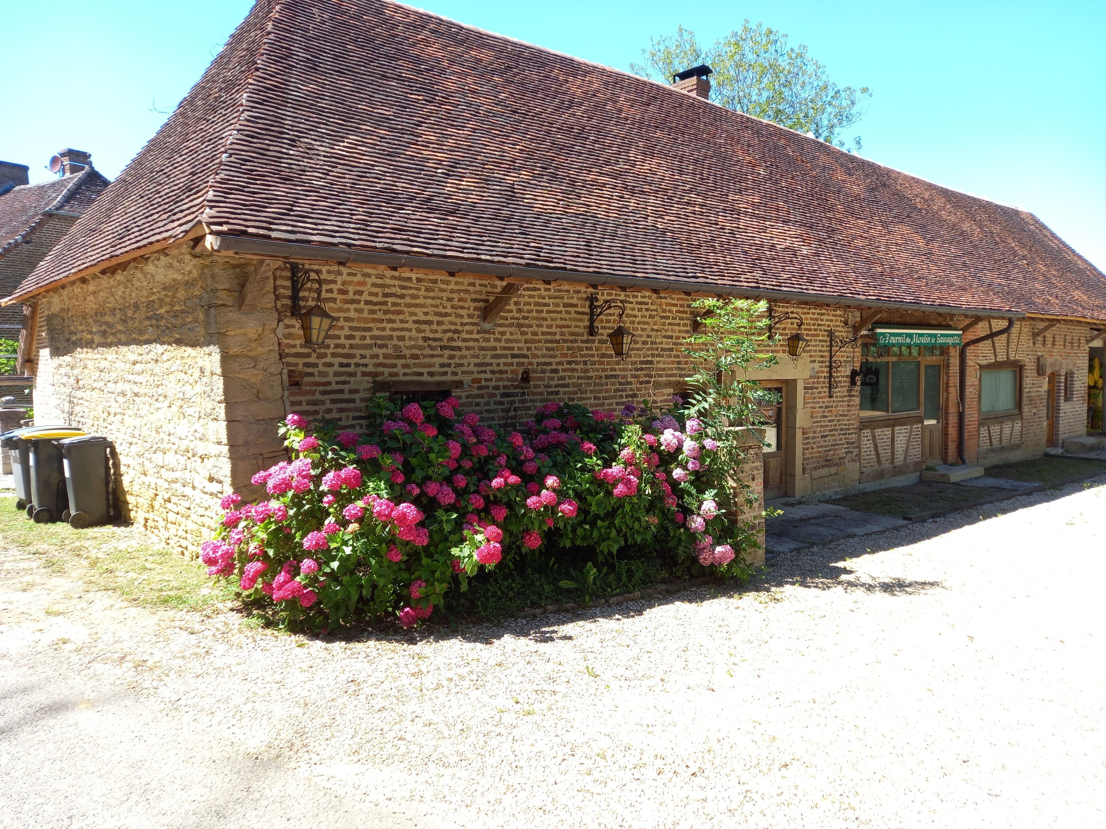 Un bâtiment de style rustique, doté d’un toit en tuiles et d’une façade en briques.