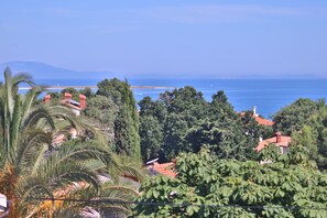 Une vue sur la côte, avec un ciel dégagé, une étendue d’eau et une chaîne de montagnes à l’horizon.