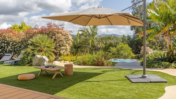 A well-maintained garden with a pool, outdoor seating, and a pergola.