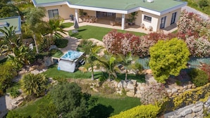 A modern house with a green roof, a swimming pool, and a well-maintained garden.