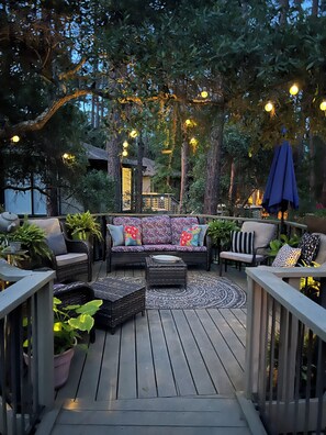 Una terraza al aire libre con sofá, sillas y una mesa.
