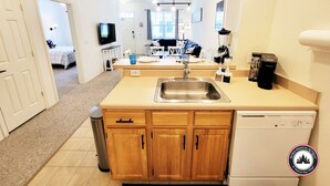 A compact kitchen with wooden cabinets, a stainless steel sink, and a dishwasher. - Mom's Magical Retreat
"Close to the Magic, but away from the mayhem!" (Kissimmee)