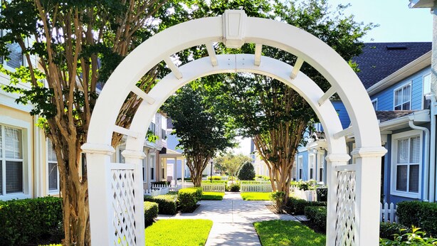 A pathway leading through a white arbor archway towards a row of townhouses. - Mom's Magical Retreat
"Close to the Magic, but away from the mayhem!" (Kissimmee)
