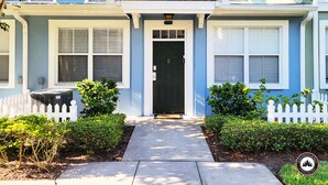 A two-story house with a front porch, a black front door, and a small garden with a white picket fence. - Mom's Magical Retreat
"Close to the Magic, but away from the mayhem!" (Kissimmee)