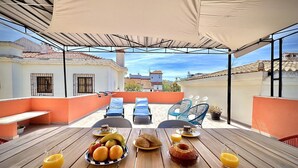 A rooftop terrace with a wooden table set for breakfast, including fruits, pastries, and beverages. - VILAMOURA CENTRAL 8 by HOMING (Vilamoura)