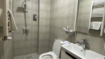 A modern bathroom with a shower, toilet, and sink.