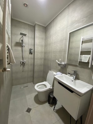 Ein modernes Badezimmer mit Dusche, Toilette und Waschbecken.