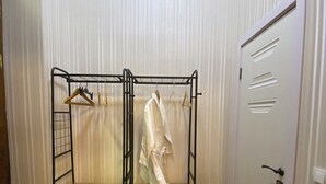 A room with a metal bunk bed, a wooden floor, a white door, and a white wall with vertical lines. - Hotel The Builder 124 (Tbilisi)