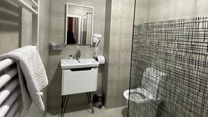 A modern bathroom with a white sink, mirror, and toilet. - Hotel The Builder 124 (Tbilisi)