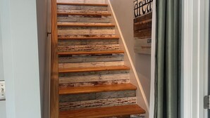 Una escalera de madera con barandilla que lleva a un piso superior.