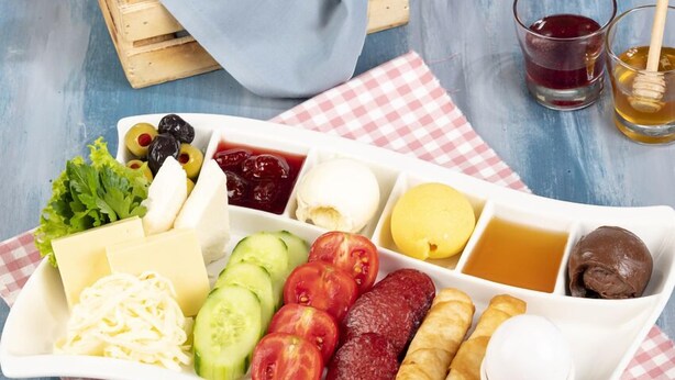 A breakfast tray with bread, cheese, vegetables, and condiments. - Frame Galata Hotel (Istanbul)