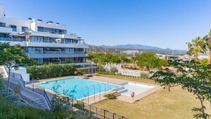 Ein modernes, mehrstöckiges Gebäude mit Swimmingpool und Bergblick.