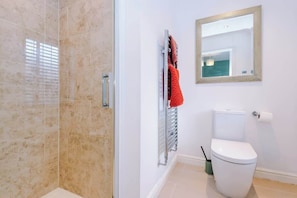 A bathroom with a shower, toilet, and a towel rack with a towel. - Charming 4BR Chester Sleeps 10 | Contractor Stays (Cheshire West and Chester)