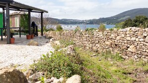 Un mur de pierre, un belvédère et une vue sur un lac.