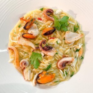 Ein Teller Meeresfrüchte-Pasta mit Muscheln und Garnelen, garniert mit Petersilie.